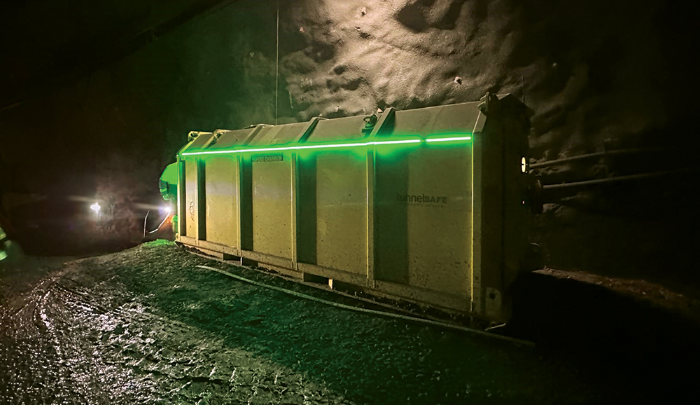A side view of green LED lighting seen attached to the outside of a mine refuge chamber.